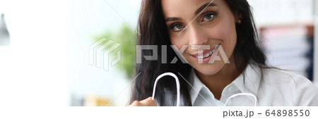 Joyful businesswoman with purchases 64898550