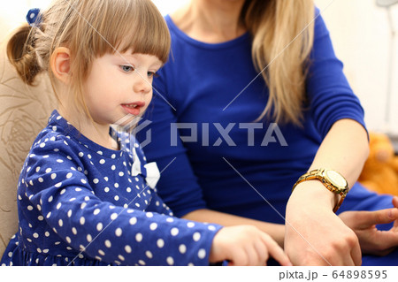 Cute little girl on couch with mom use laptop 64898595