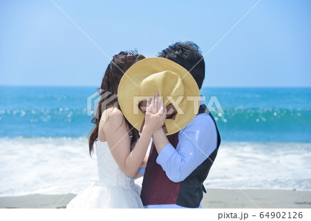 海岸で内緒話しをている幸せな二人（静岡県浜松市中田島海岸） 64902126