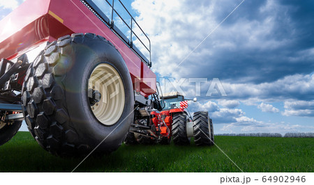 Back view of tractor on a agricultural field 64902946
