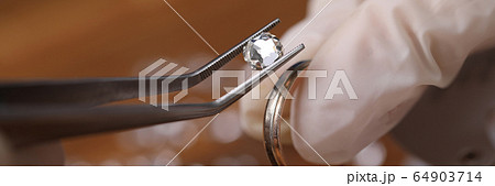 Jeweller installing gemstone 64903714