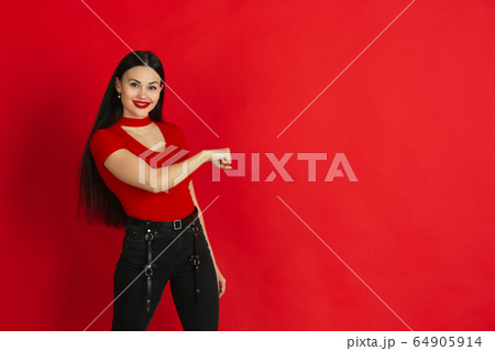 Caucasian young woman's monochrome portrait on red studio background, emotional and expressive Caucasian young woman's monochrome portrait on red studio background, emotional and expressive 64905914