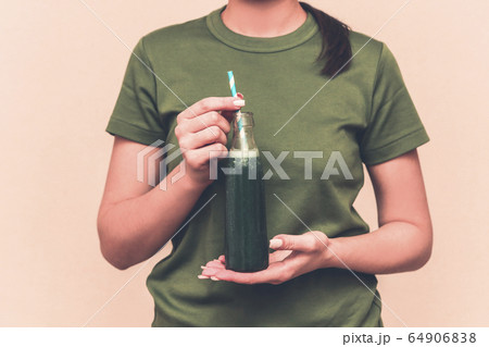 Happy brunette woman drinking fresh raw green 64906838