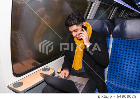 Businessman calls on phone and works on laptop 64908078