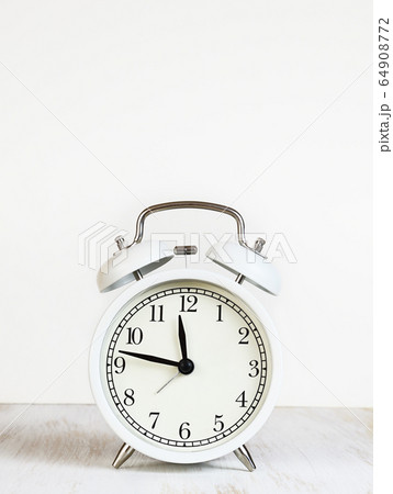 White alarm clock on table White alarm clock on table 64908772