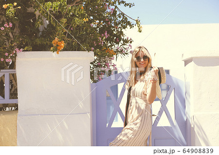 Happy young woman smiling against blue wooden door Happy young woman smiling against blue wooden door 64908839