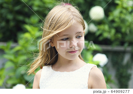 Happy little girl in green summer garden Happy little girl in green summer garden 64909277