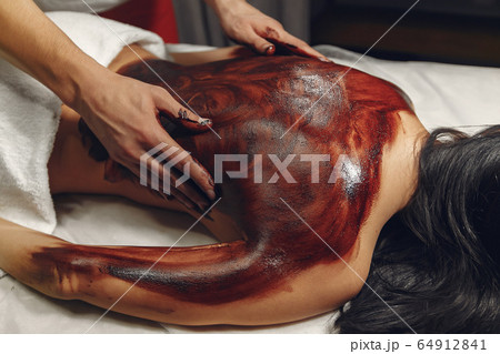 The doctor massages the woman with a chocolate The doctor massages the woman with a chocolate 64912841