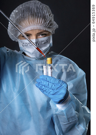 Girl examines a test tube with biomaterial. Young Girl examines a test tube with biomaterial. Young 64915369