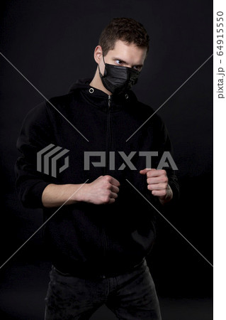 Man in black in a fighting pose with clenched 64915550