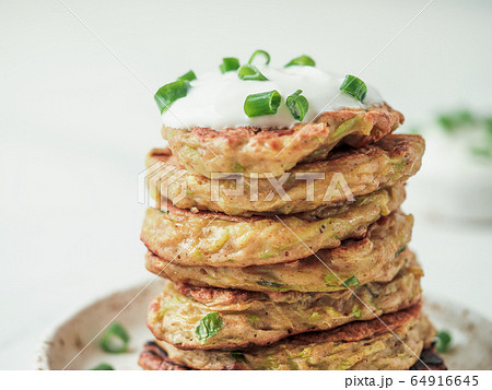 Traditional zucchini fritters, served sour cream Traditional zucchini fritters, served sour cream 64916645