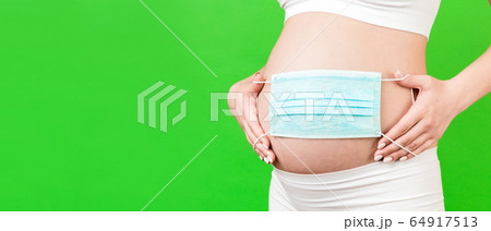 banner of medical mask on the belly of a pregnant 64917513
