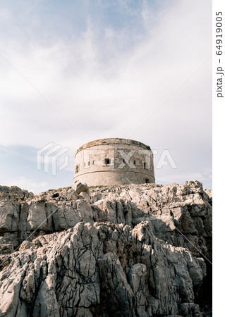 The ancient Austro-Hungarian fort Arza at the entrance to the Bay of Kotor in Montenegro, in the Adriatic Sea, on Lustica peninsula. Fortress for military defense. Stone tower built in 19th century. 64919005