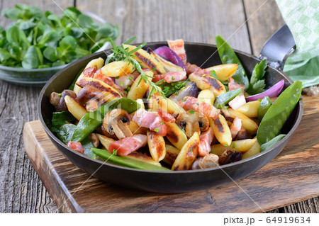 Bavarian fried finger-shaped potato dumplings with vegetable and smoked bacon 64919634