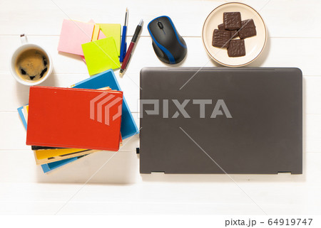 Home office concept. Work from home. Black laptop, books and cafe cuo on the white wooden background. Top view. Home office concept. Work from home. Black laptop, books and cafe cuo on the white wooden background. Top view. 64919747
