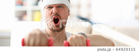 Guy fulfills strokes with dumbbells in his hands Guy fulfills strokes with dumbbells in his hands 64920315