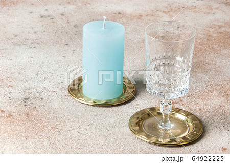 Blue candle and wineglass on brass small dishes 64922225