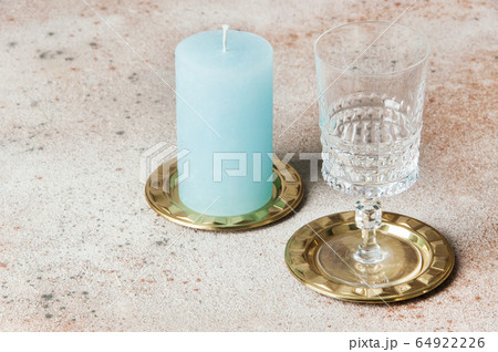 Blue candle and wineglass on brass small dishes 64922226