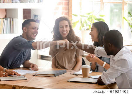 Happy diverse male colleagues students fist bumping at group meeting Happy diverse male colleagues students fist bumping at group meeting 64924405