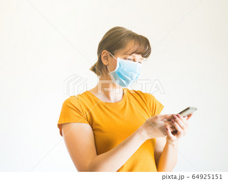 Young woman in face mask using smartphone Young woman in face mask using smartphone 64925151