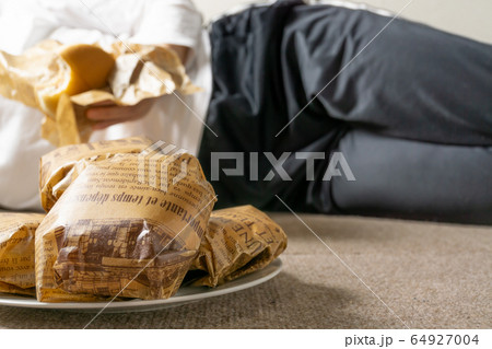 床に寝そべってハンバーガーを食う女　ぐうたら女　干物女　過食症イメージ 64927004