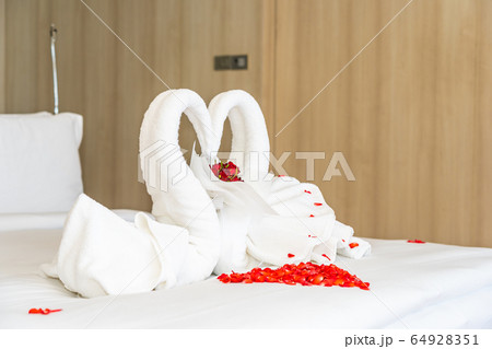 Swan towel on bed with red rose flower decoration interior 64928351