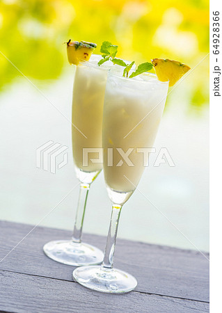 Ice cocktails glass on wooden floor around outdoor swimming pool 64928366