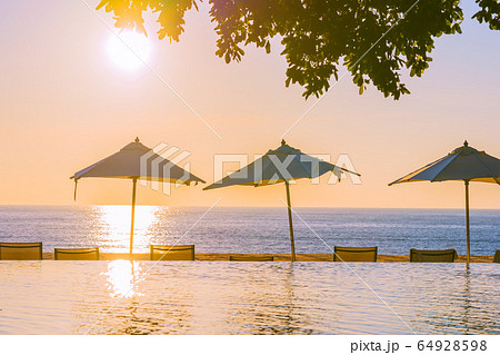 Beautiful tropical outdoor beach sea ocean with umbrella and chiar around outdoor swimming pool at sunset or sunrise time Beautiful tropical outdoor beach sea ocean with umbrella and chiar around outdoor swimming pool at sunset or sunrise time 64928598