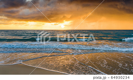 Beach under dramatic sky at sunset 64930234