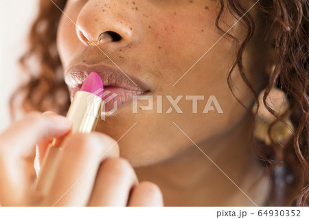 Woman applying lipstick 64930352