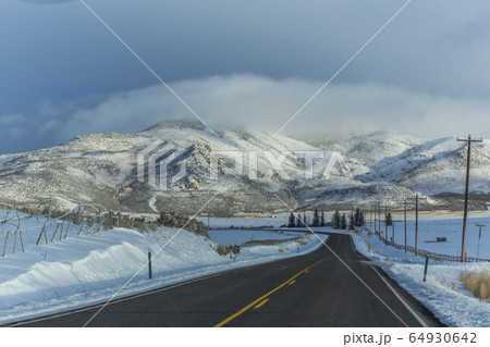 Road with snowy mountains in distance 64930642