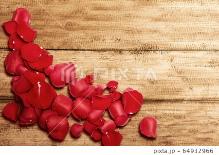 Red rose petals on wooden table 64932966