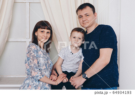 Warming and relaxing. Mother, father and son hugging. Concept of family , motherhood, interior, home, childhood, mother's day, children's day Warming and relaxing. Mother, father and son hugging. Concept of family , motherhood, interior, home, childhood, mother's day, children's day 64934193