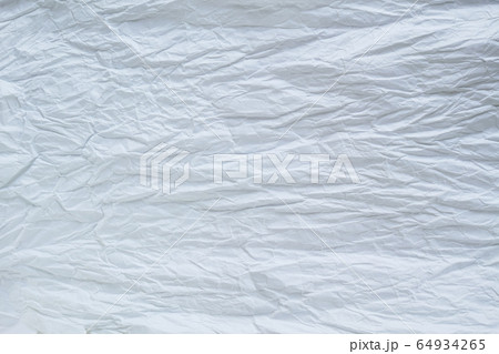 白い紙をよじって広げた時にできた皺のテクスチャの写真素材