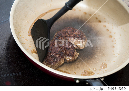 牛ヒレ肉ステーキをフライパンで焼く 64934369