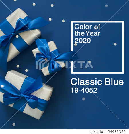 Festive Christmas decor on a blue classic background. Silver gift boxes, confetti, sparkles, ribbons, bows. Color of the year 2020. Festive Christmas decor on a blue classic background. Silver gift boxes, confetti, sparkles, ribbons, bows. Color of the year 2020. 64935362