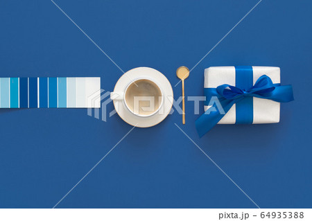 Classic Blue. Color of the Year 2020. Top view of workspace with coffe, gift and glasses and copy space on colored blue background. Flatlay minimalism Classic Blue. Color of the Year 2020. Top view of workspace with coffe, gift and glasses and copy space on colored blue background. Flatlay minimalism 64935388