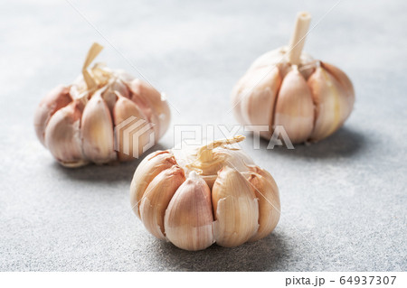 Whole garlic heads on a concrete grey background. Whole garlic heads on a concrete grey background. 64937307