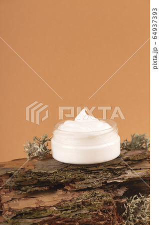 Cream for the face on the bark of a tree. Natural care concept. Cream for the face on the bark of a tree. Natural care concept. 64937393