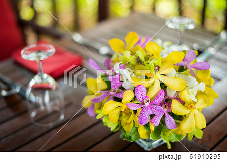 colorful beautiful orchid bouquet decor in glass vase setup on wooden dinner table colorful beautiful orchid bouquet decor in glass vase setup on wooden dinner table 64940295