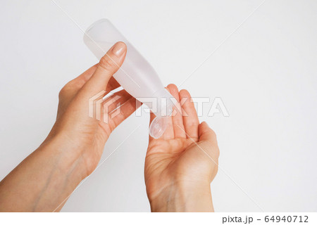 Woman disinfecting her hands using sanitaser gel. 64940712