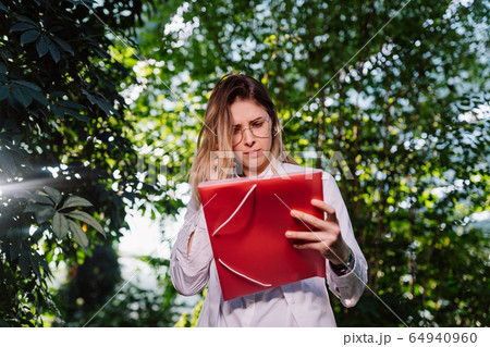 Young female agricultural engineer working in greenhouse. 64940960