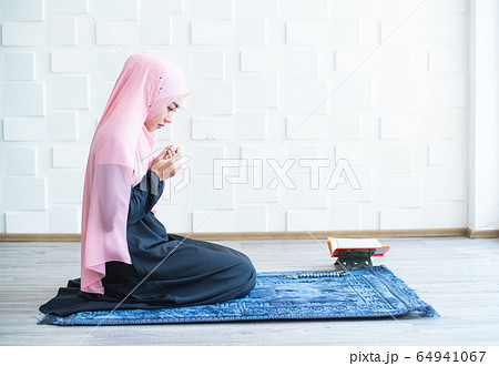 muslim woman pray on hijab praying on mat indoors 64941067