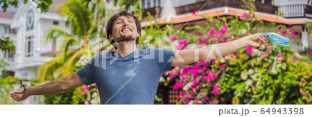 Quarantine is over concept. Man taking off mask against the background of small town houses. We are 64943398