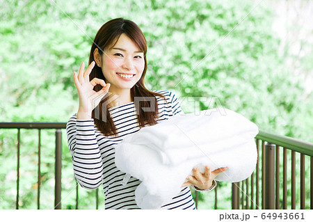 洗濯物を取り込む女性 洗濯物を取り込む女性 64943661