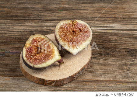 ripe fig fruit cut in half on a wooden table ripe fig fruit cut in half on a wooden table 64944756