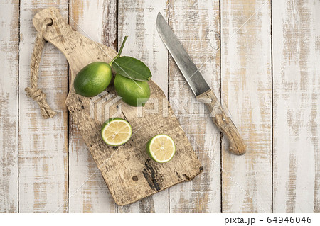 sliced limes on a wooden cutting board on a table 64946046