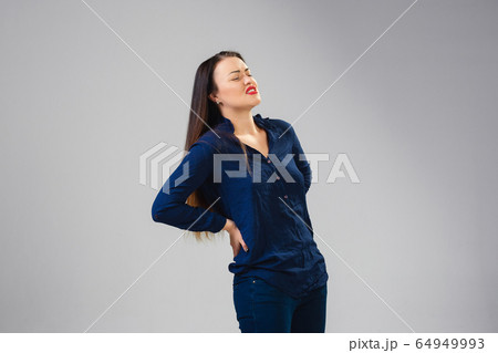 Young woman suffers from pain, feels sick, ill and weakness isolted on studio background Young woman suffers from pain, feels sick, ill and weakness isolted on studio background 64949993