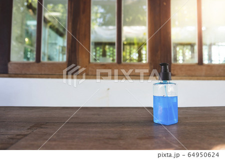 Close-up of 70% Blue Ethyl alcohol gel in the plastic bottle on the wooden desk for coronavirus protection Close-up of 70% Blue Ethyl alcohol gel in the plastic bottle on the wooden desk for coronavirus protection 64950624