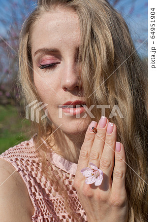 Ladybird and blonde woman in flowering garden 64951904